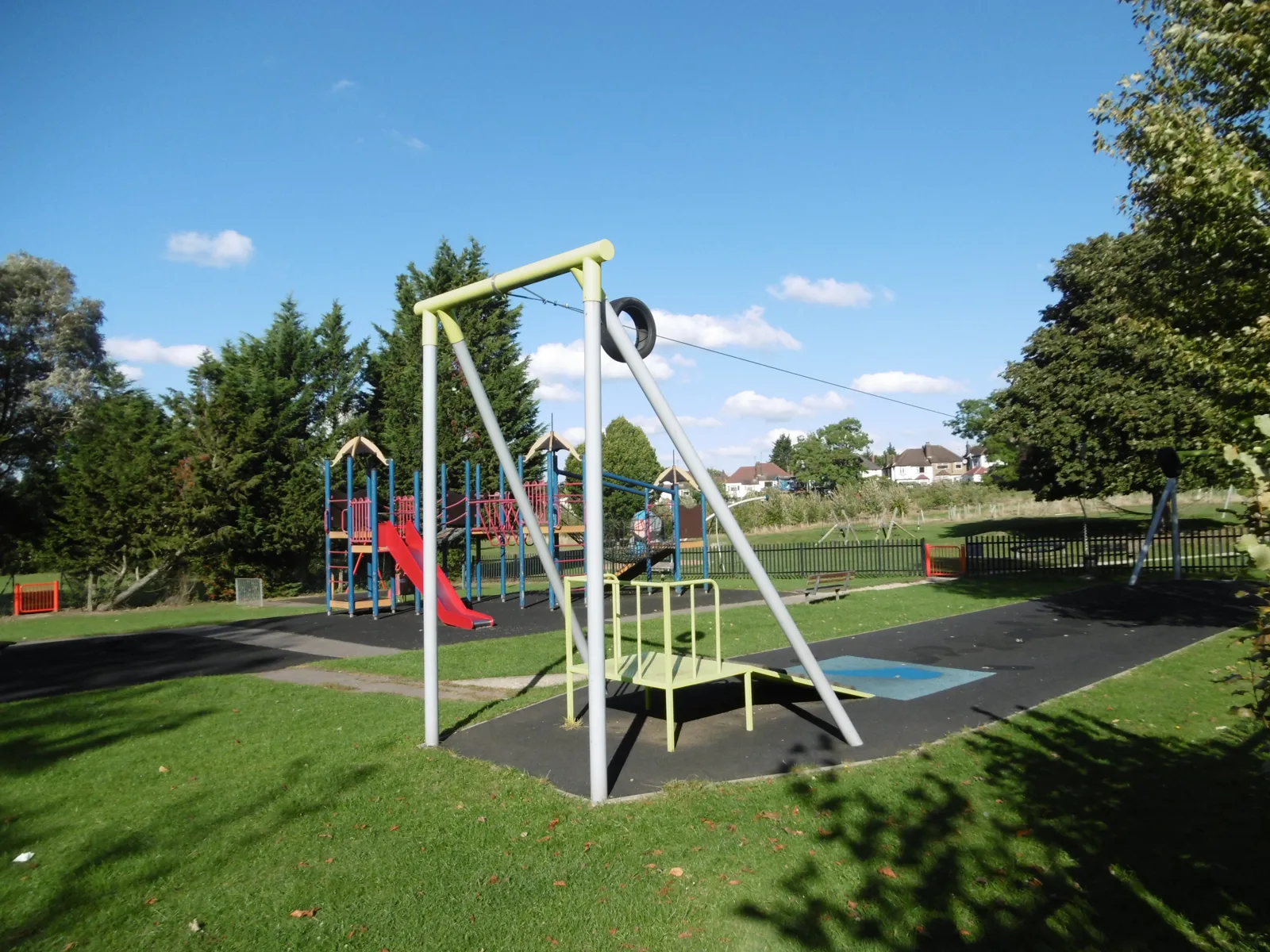 The playground in Sunny Hill Park, Hendon, with a zip wire in front and the climbing frame and slide behind